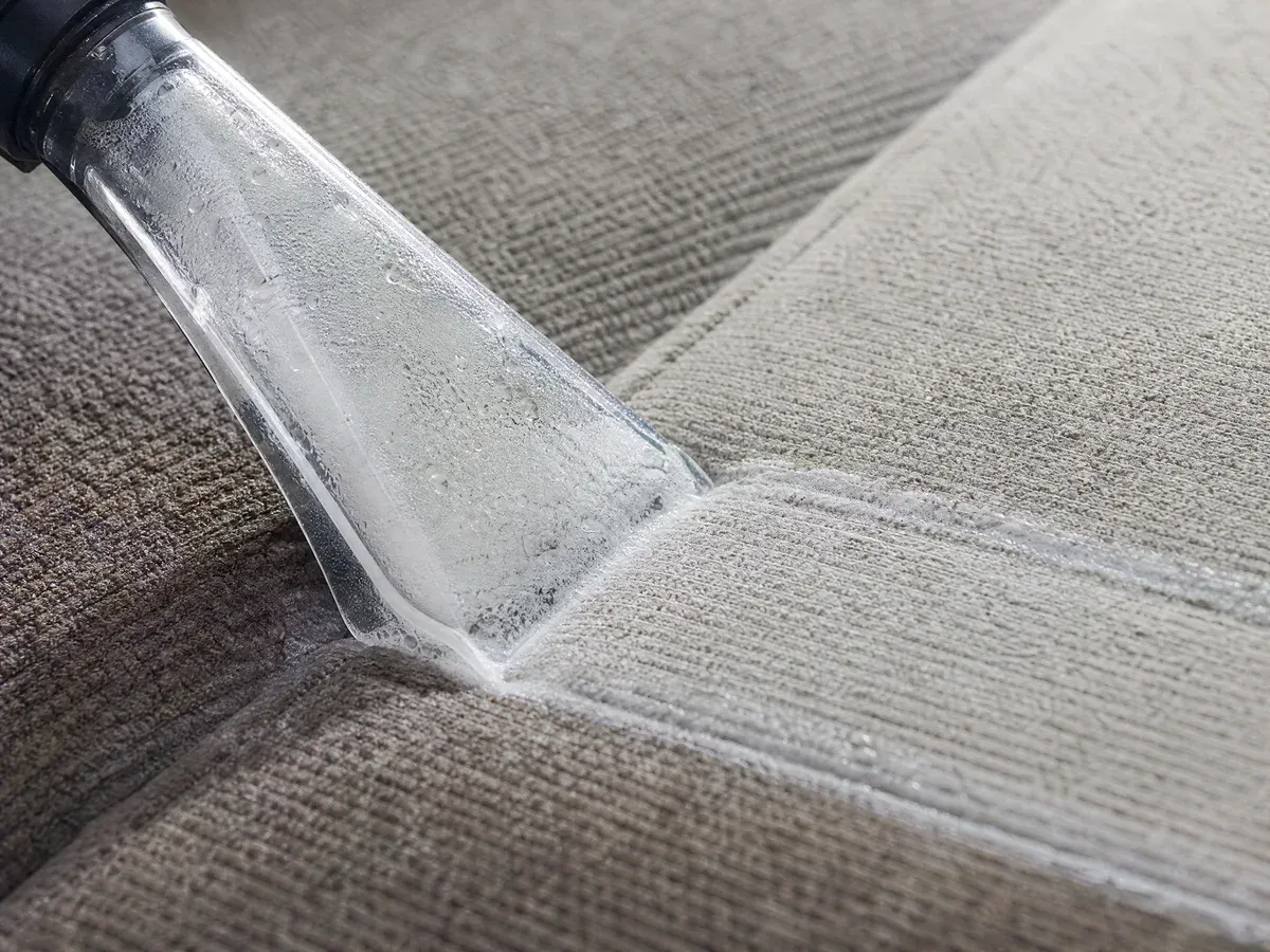 Close-up of a wet-extraction tool deep-cleaning textured seat fabric, lifting embedded dirt from the fibers — Prestige Marine & Auto Care in Seattle, WA.
